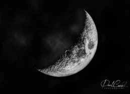 Crescent Moon astrophotography showing detailed lunar craters and rugged terrain along the terminator against a dark night sky.